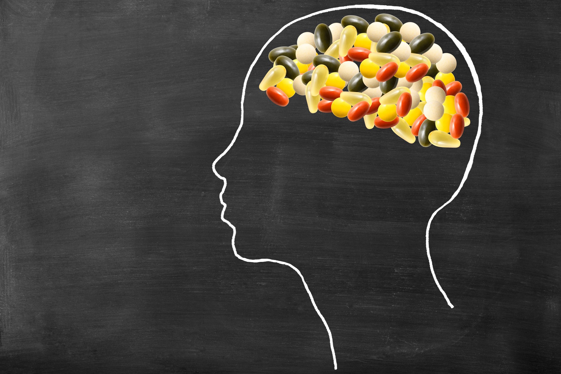 Human head drawn on the blackboard with nutritional supplement